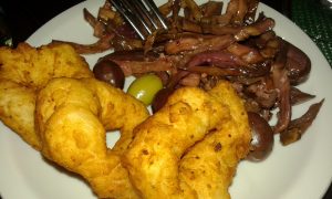 el platito es cada dos comensales: lo spuntino (alguna cosita para ir picando) aceitunas verdes y negras, berenjenas aliñadas y zeppole (buñuelos de papa y cebolla frito)